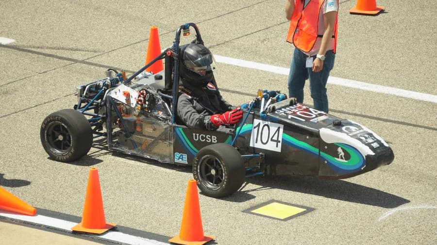 The UCSB car, number 104, staged between cones at the start of a run with the driver seated.