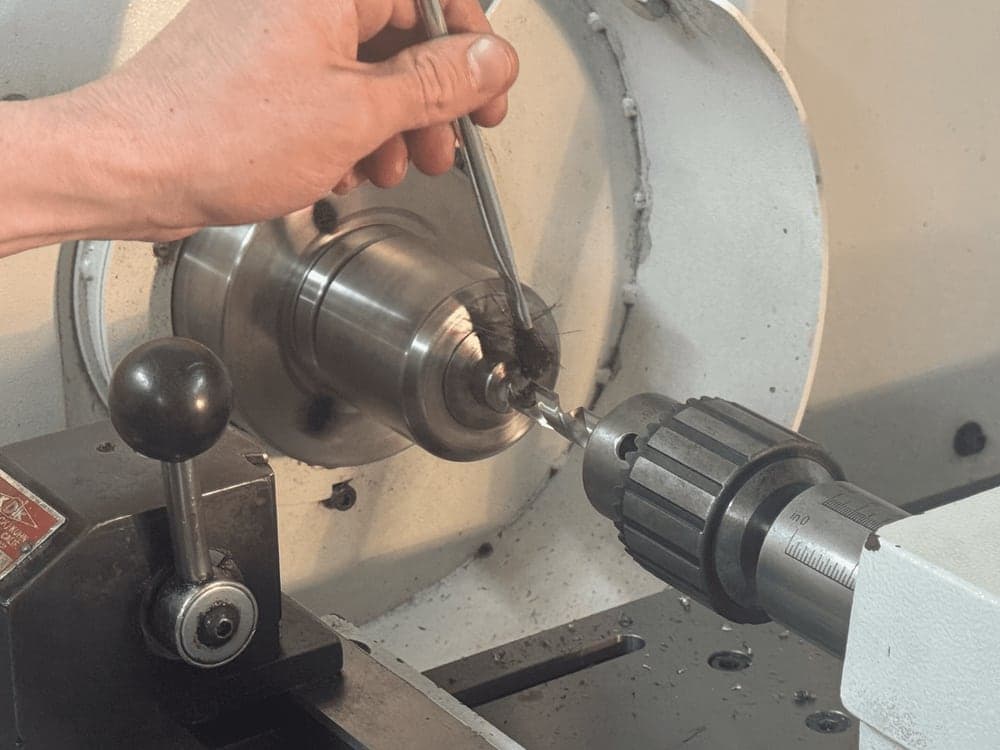 Turning a mounting shaft on the lathe, working the tailstock by hand.